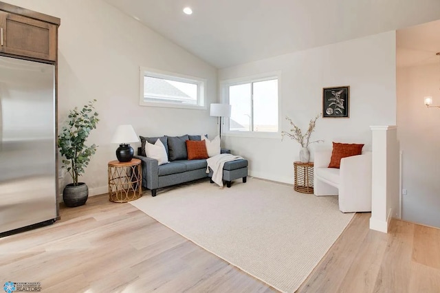 living room featuring light hardwood / wood-style flooring and vaulted ceiling