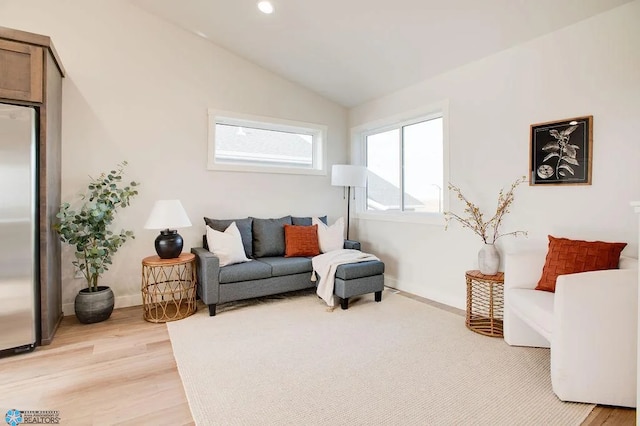 living room featuring light wood-type flooring and lofted ceiling