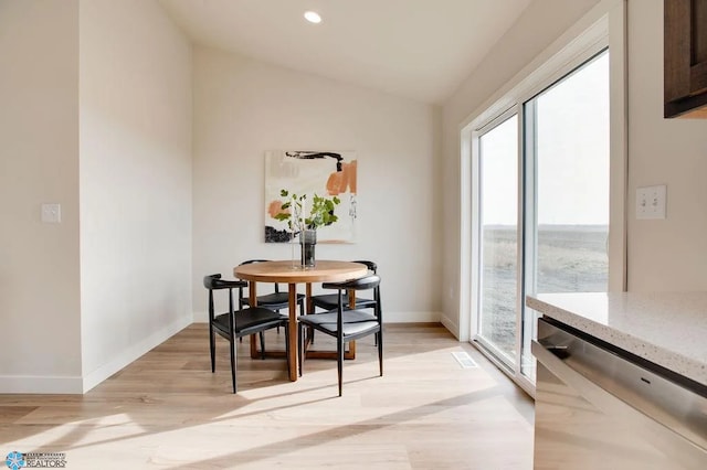 dining space featuring light hardwood / wood-style floors and lofted ceiling