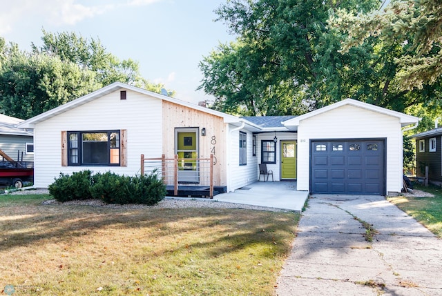 single story home featuring a garage and a front lawn