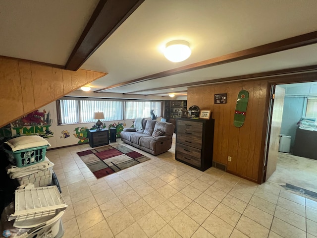 living room with wooden walls, light tile patterned flooring, and beam ceiling