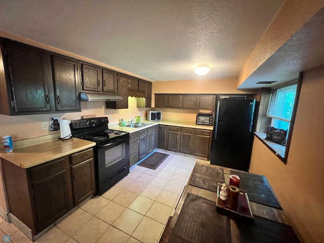 kitchen with a textured ceiling, black appliances, light tile patterned flooring, and dark brown cabinets