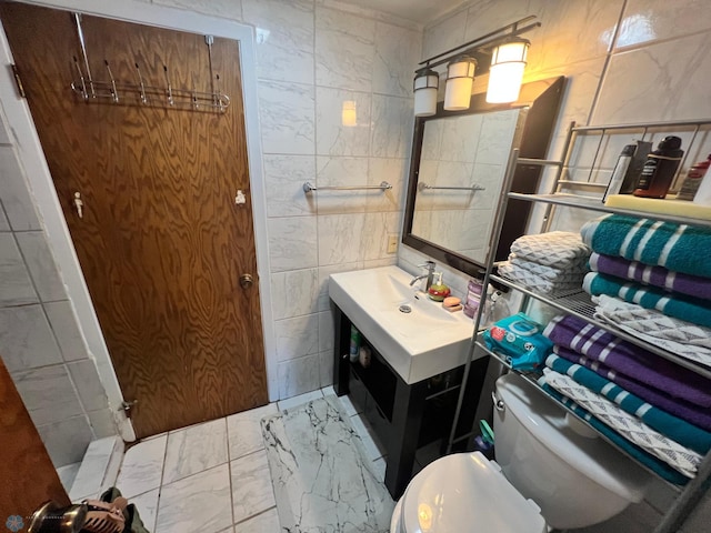 bathroom with vanity, tile walls, and toilet