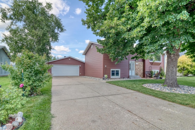 view of front of house with a garage, a front yard, and an outbuilding