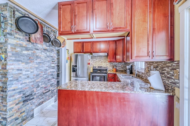 kitchen featuring light stone countertops, stainless steel appliances, sink, and kitchen peninsula