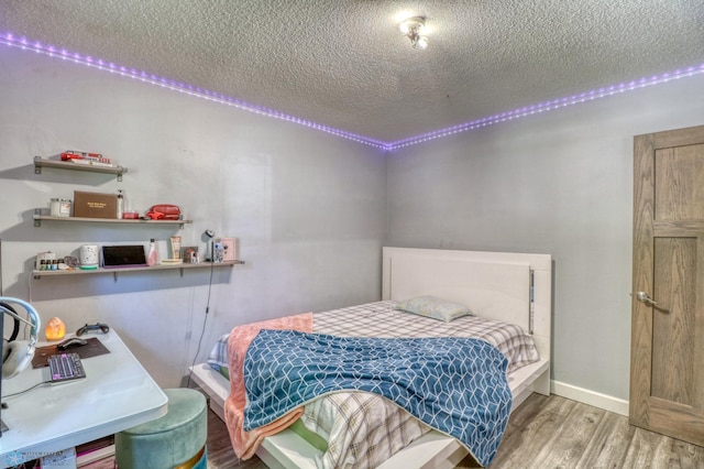 bedroom with hardwood / wood-style flooring and a textured ceiling