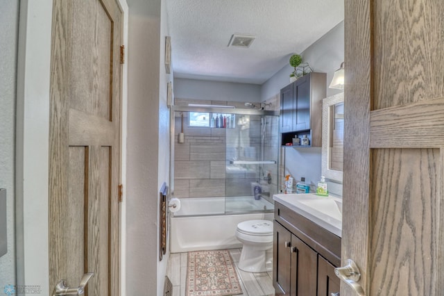 full bathroom featuring vanity, enclosed tub / shower combo, wood-type flooring, a textured ceiling, and toilet