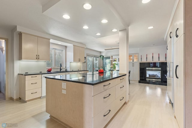 kitchen with a textured ceiling, stainless steel dishwasher, light hardwood / wood-style floors, and a center island