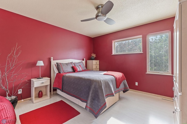 bedroom with ceiling fan and a textured ceiling