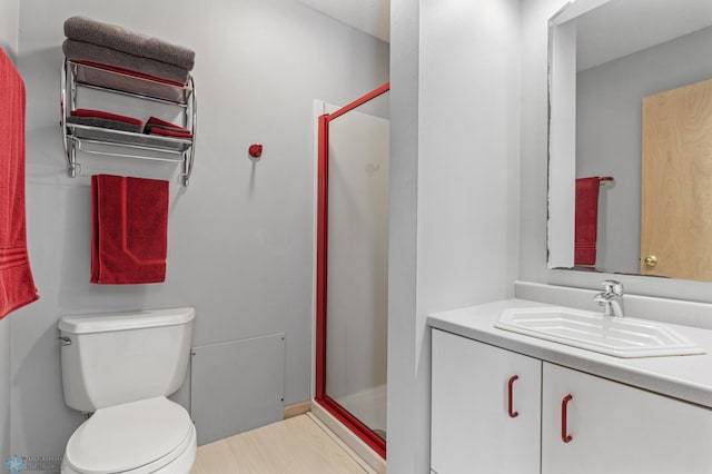 bathroom featuring vanity, hardwood / wood-style flooring, an enclosed shower, and toilet