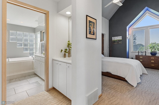 carpeted bedroom featuring ceiling fan, connected bathroom, and vaulted ceiling