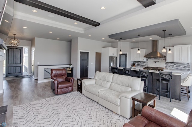 living room with beam ceiling, light hardwood / wood-style floors, and a raised ceiling