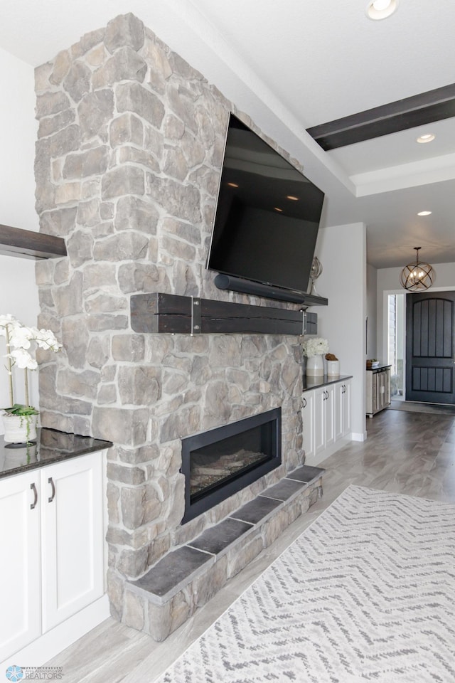 living room with light wood-type flooring and a stone fireplace