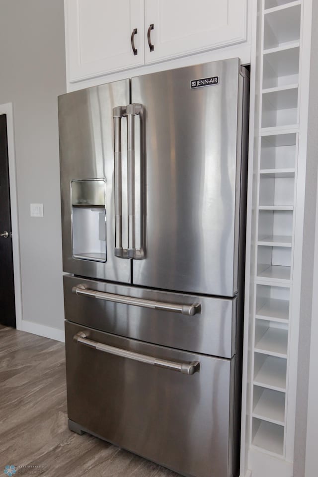 room details featuring high end fridge, white cabinets, and dark hardwood / wood-style flooring