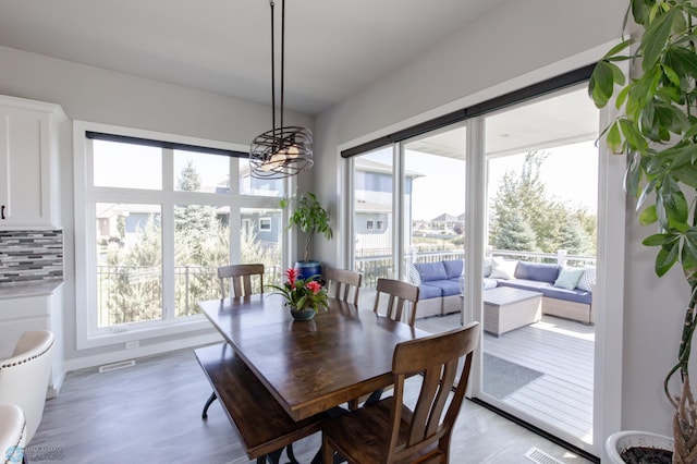 dining area featuring a chandelier, light hardwood / wood-style floors, and a wealth of natural light