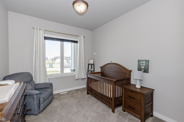 bedroom with a crib and light colored carpet