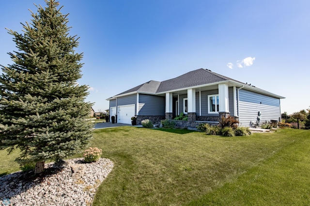 view of front of property featuring a front yard, a garage, and covered porch