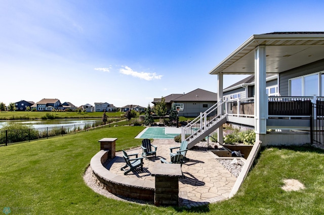 view of yard with an outdoor fire pit, a patio area, and a deck with water view