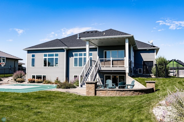 back of house featuring a yard, basketball hoop, and a patio