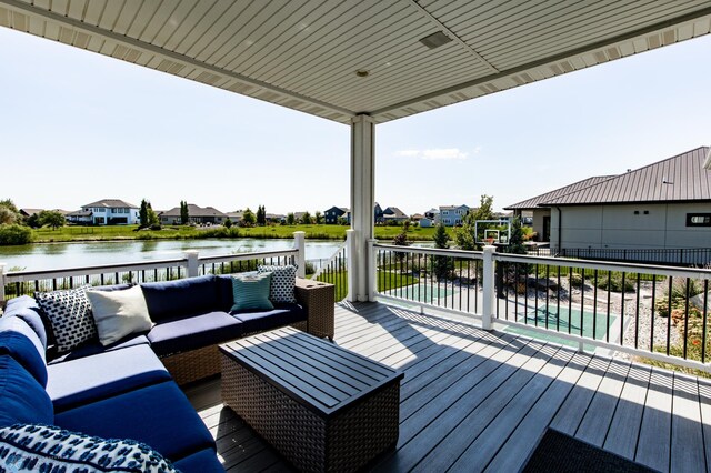 deck with an outdoor living space and a water view