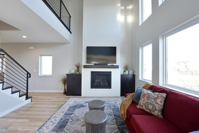 living room with a high ceiling and light hardwood / wood-style floors