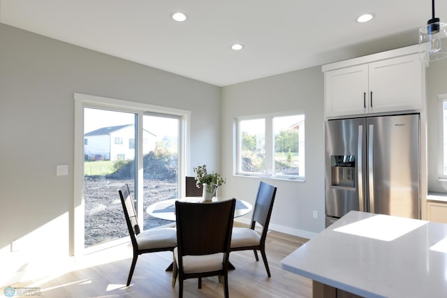 dining space with a healthy amount of sunlight and light hardwood / wood-style floors