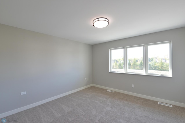 spare room featuring light colored carpet