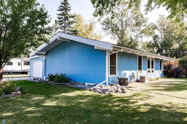 rear view of house with a garage and a yard