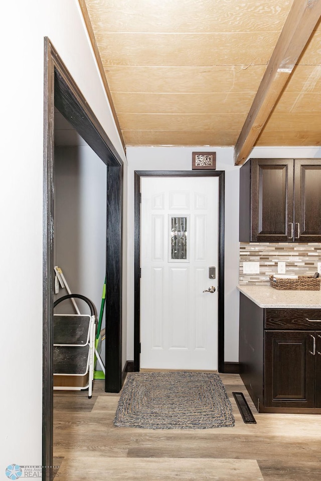 entrance foyer with light wood-type flooring, beam ceiling, and wooden ceiling