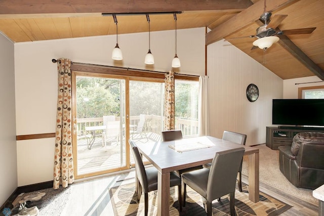 dining room featuring lofted ceiling with beams, wooden ceiling, and a healthy amount of sunlight