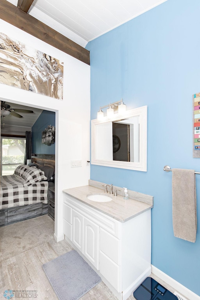 bathroom featuring ceiling fan, vanity, beam ceiling, and wood-type flooring