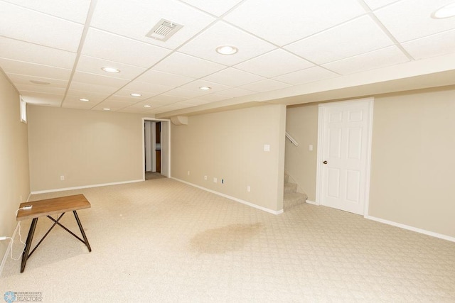 basement featuring carpet floors and a paneled ceiling