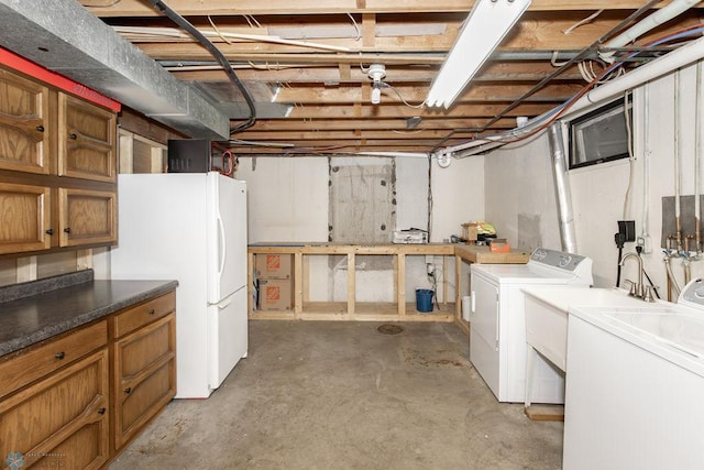 basement featuring washer and clothes dryer and white fridge