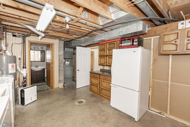 basement featuring separate washer and dryer, white fridge, and sink