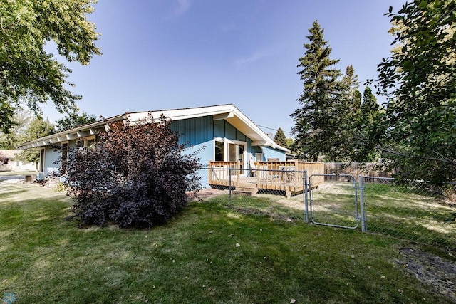 back of house with a lawn and a wooden deck