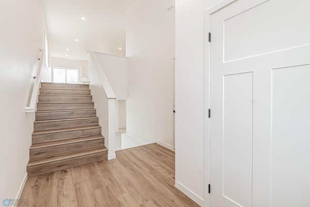 stairs featuring hardwood / wood-style floors