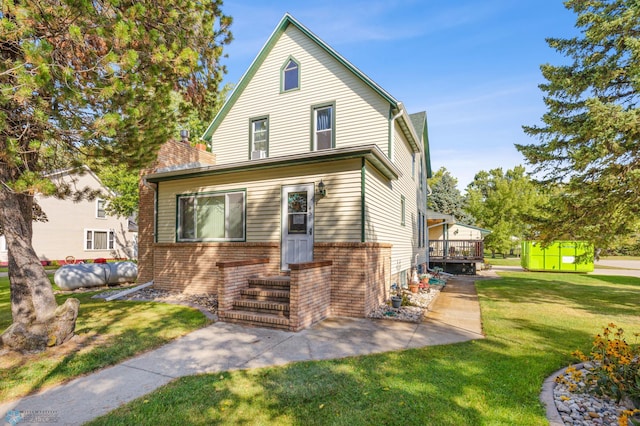 view of front of house featuring a front yard, a storage shed, and a wooden deck