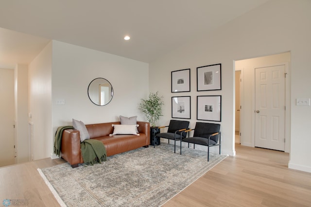 living room featuring lofted ceiling and light hardwood / wood-style floors