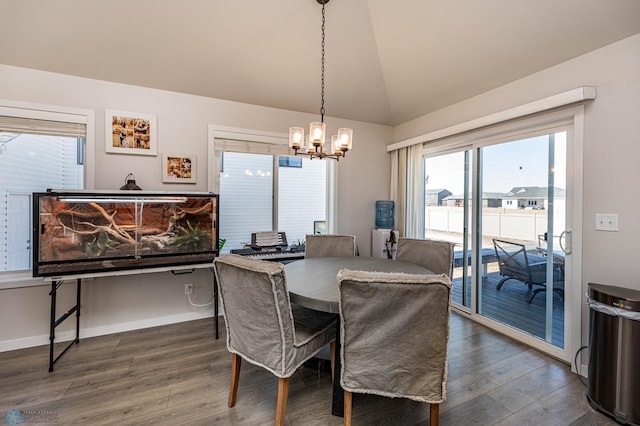 dining space with vaulted ceiling, an inviting chandelier, and dark wood-type flooring