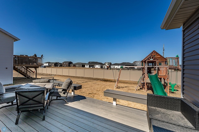 wooden terrace with a playground and an outdoor fire pit