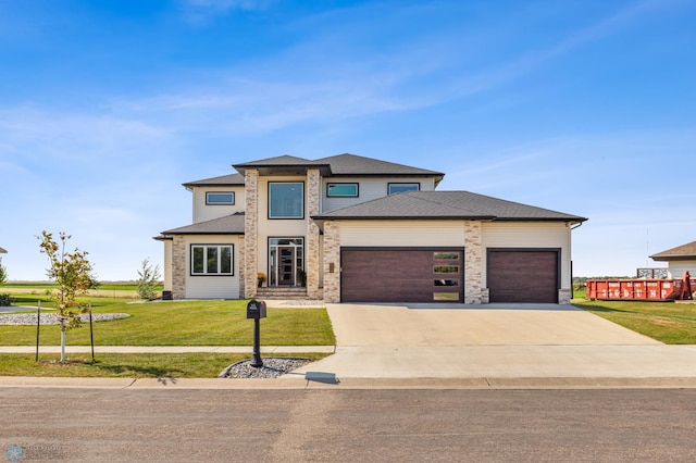 prairie-style home with a garage and a front lawn