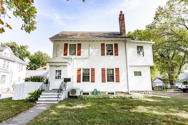 view of front of house with a front yard and ac unit