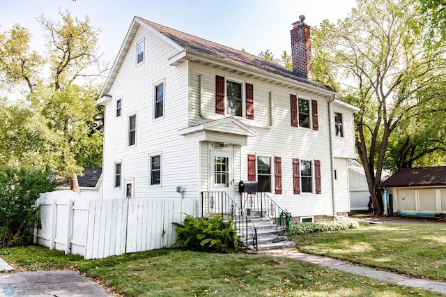 colonial house featuring a front lawn