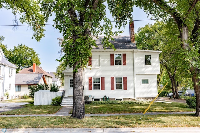 view of front facade featuring a front yard and ac unit