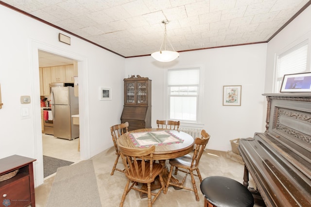 carpeted dining room featuring ornamental molding and plenty of natural light