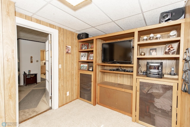 bar featuring wood walls, light colored carpet, and a paneled ceiling