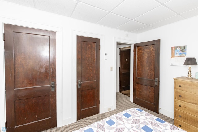 carpeted bedroom featuring a drop ceiling