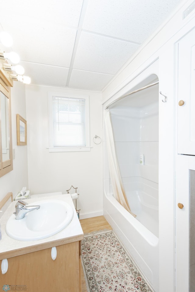 bathroom with shower / tub combo with curtain, hardwood / wood-style flooring, and vanity