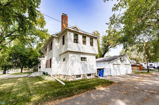 exterior space with a garage, an outdoor structure, and a yard