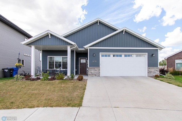 craftsman house featuring a front yard, a porch, and a garage